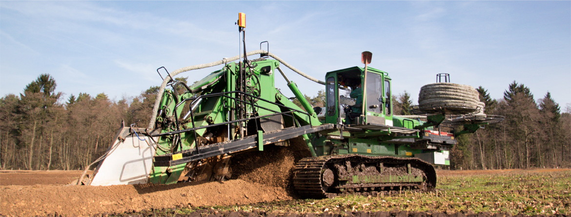 A green tractor with a large blade on the front.