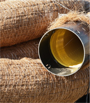 A bunch of brown hay with a yellow tube in the middle.