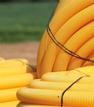A bunch of yellow pipes with a black cord around them.