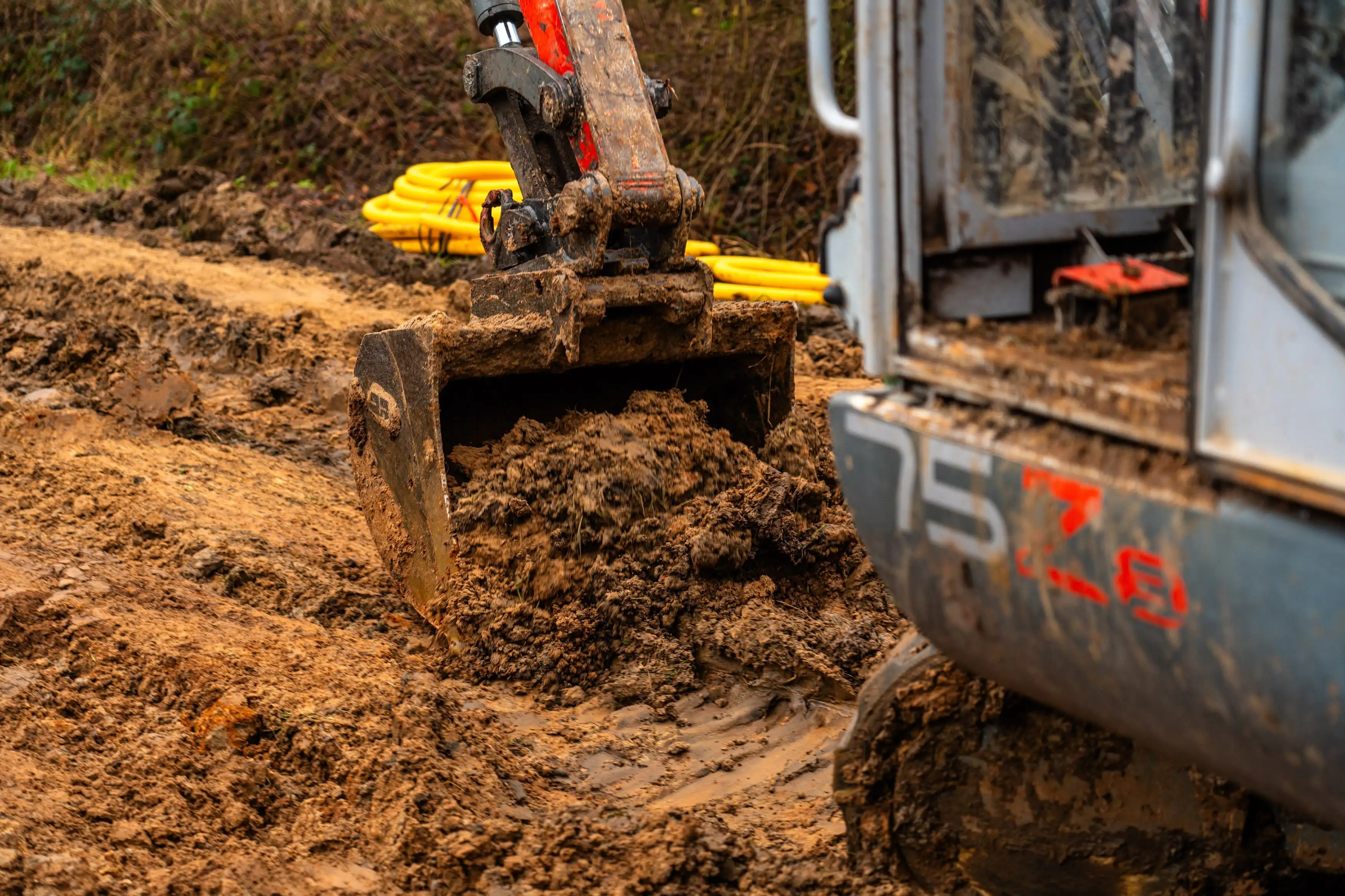 A large construction vehicle is stuck in mud.