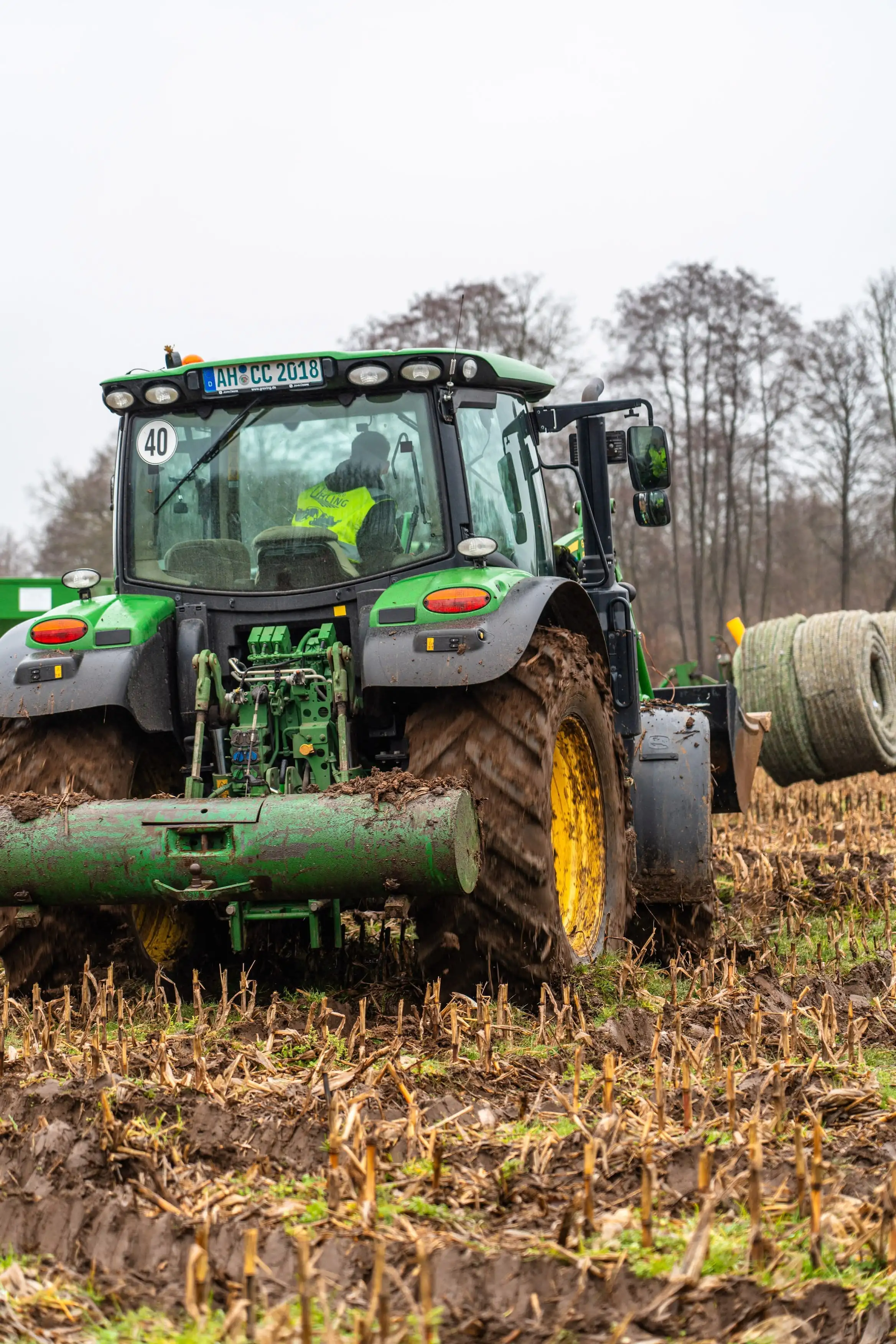 A green tractor with a yellow front tire.