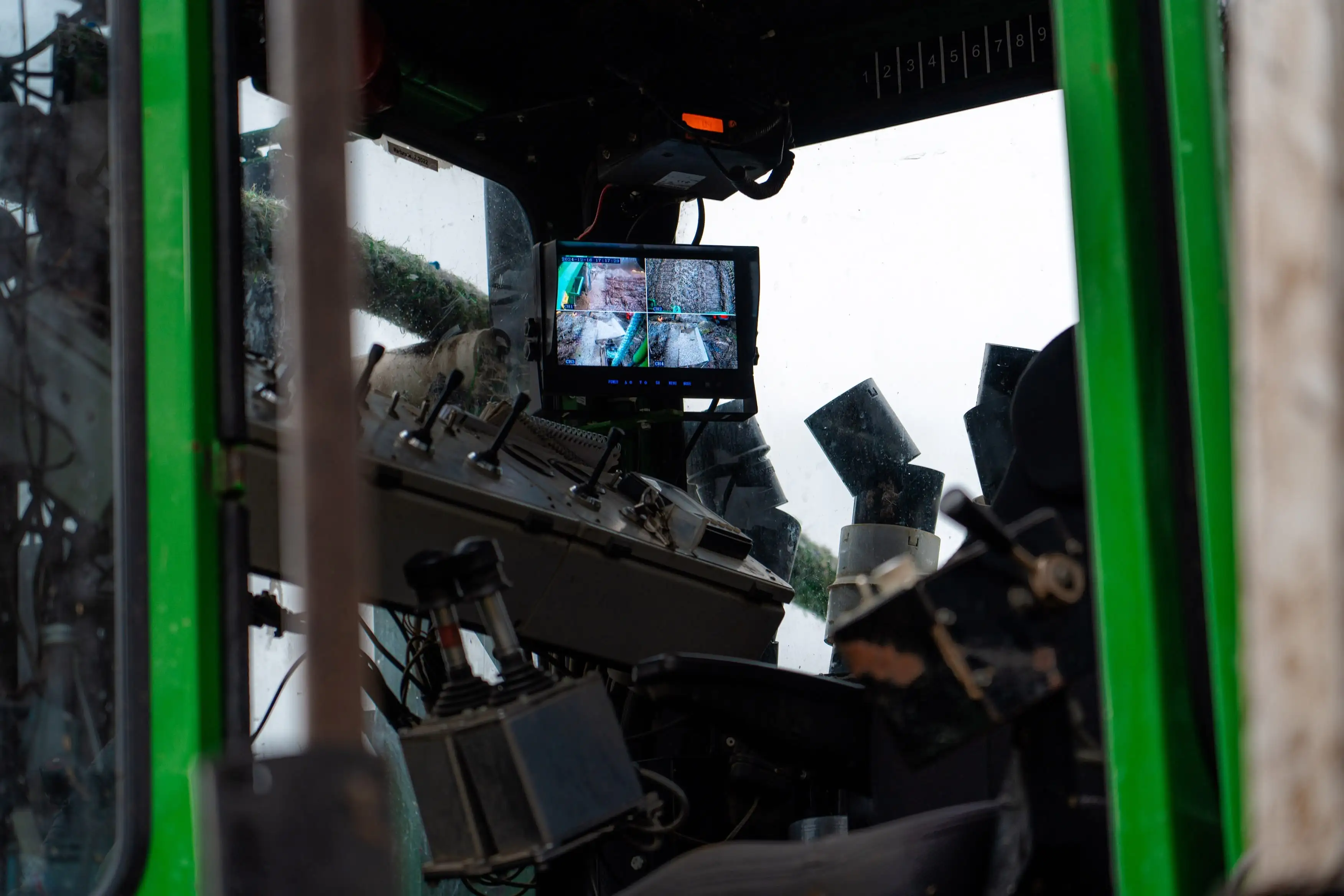 A person is sitting in a vehicle with a monitor in front of them.