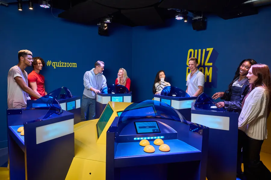 Group of friends buzzing in during competitive quiz night