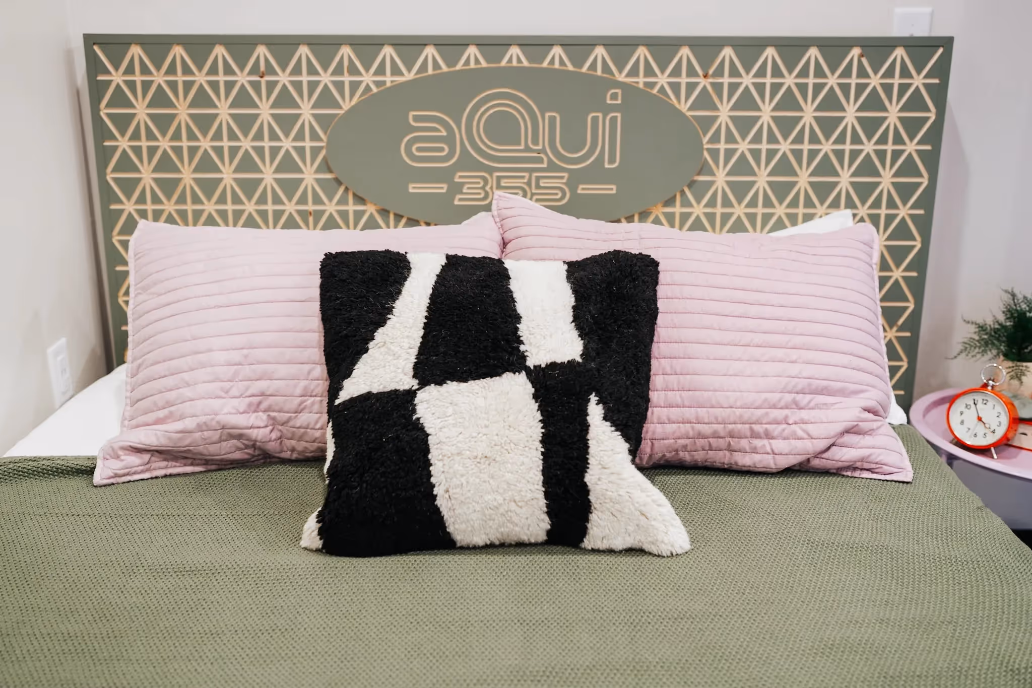 Close-up of a stylish headboard with the aQui355 logo and geometric design in a bedroom at aQui355 apartments, Salt Lake City, Utah.