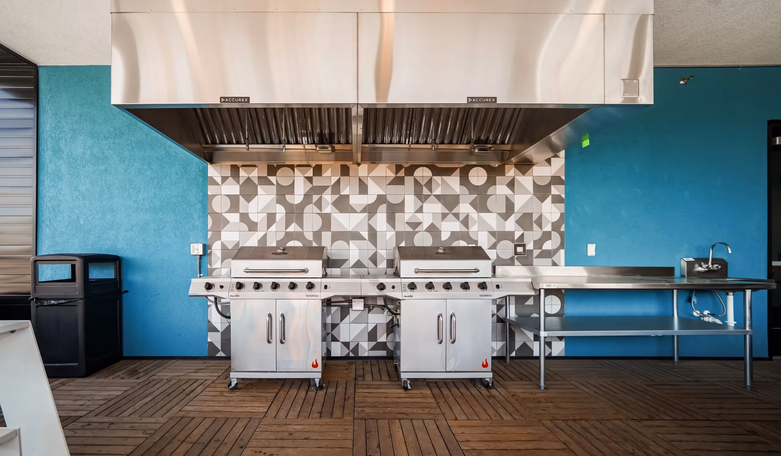 Outdoor grilling station with two large stainless steel grills and a prep sink at aQui355 apartments in Salt Lake City, Utah.