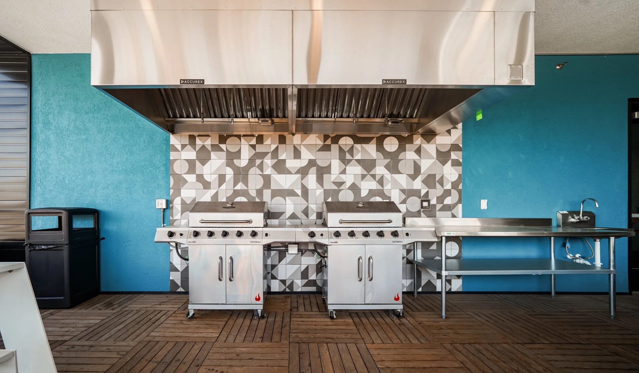 Outdoor grilling station with two large stainless steel grills and a prep sink at aQui355 apartments in Salt Lake City, Utah.