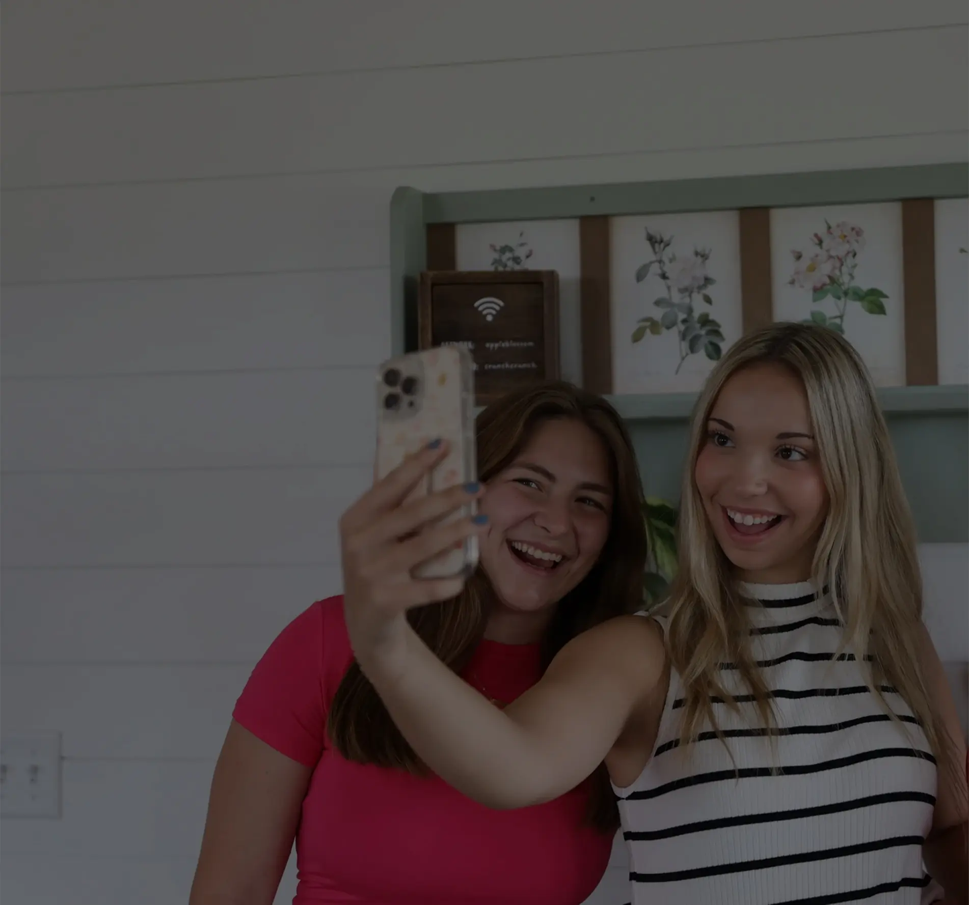 2 women posing for a picture on an iphone