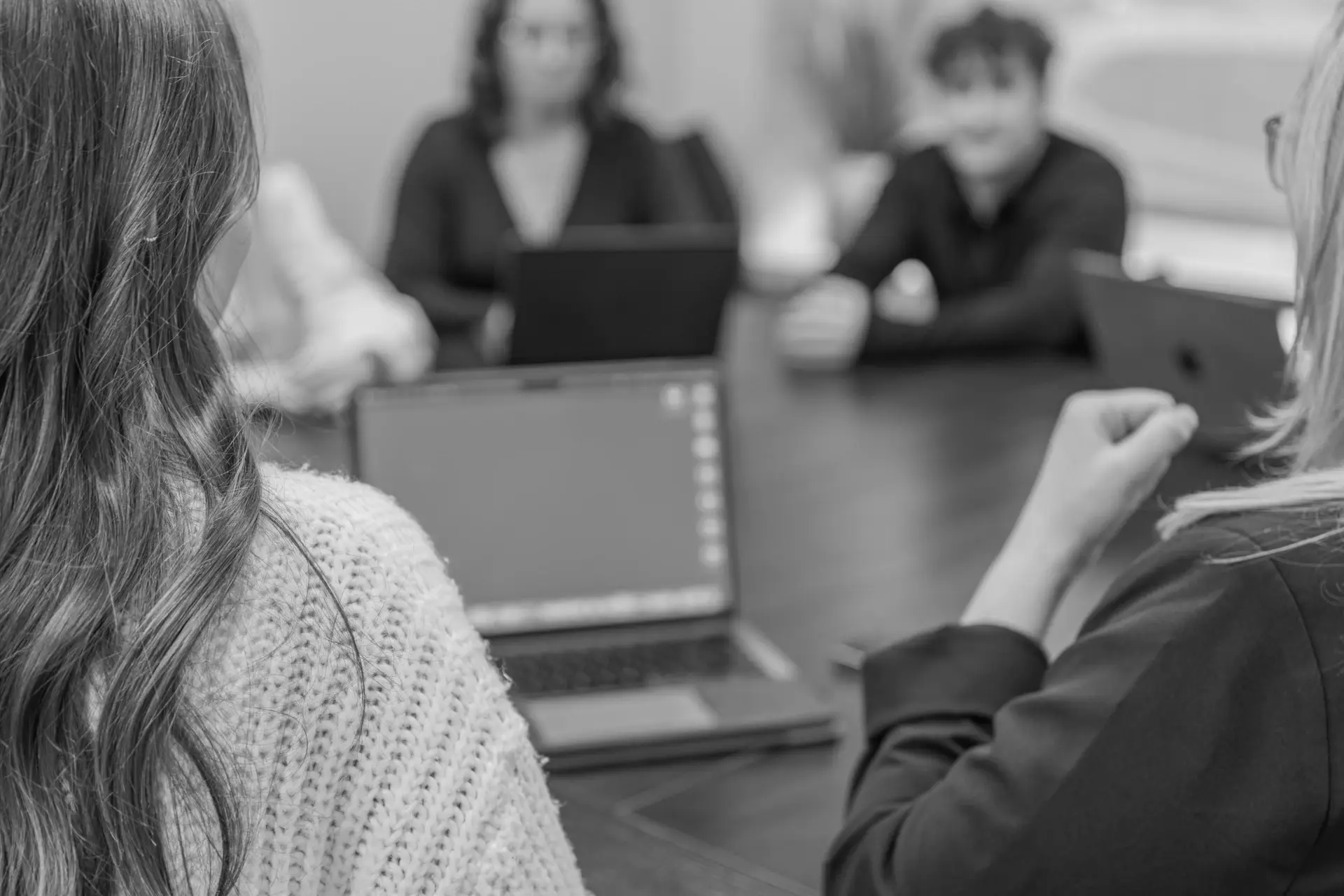 team around table with laptops