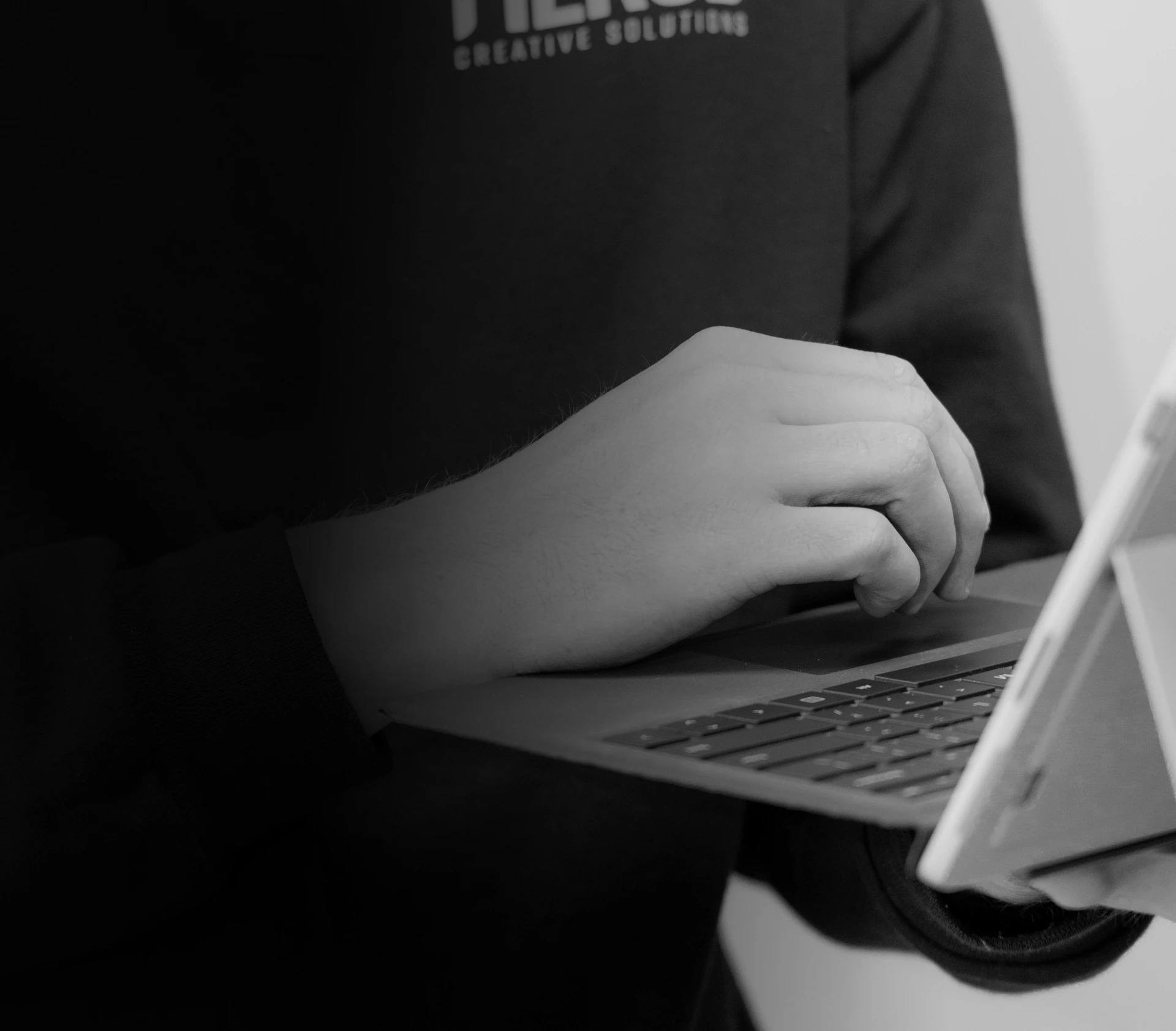 hand resting on laptop keyboard while holding
