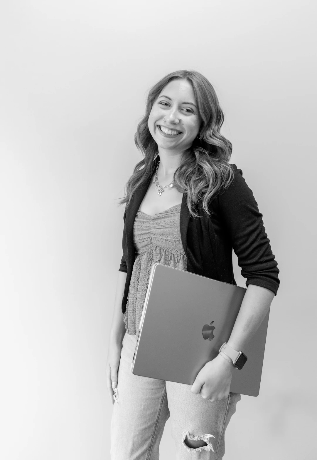 social media manager holding laptop at side