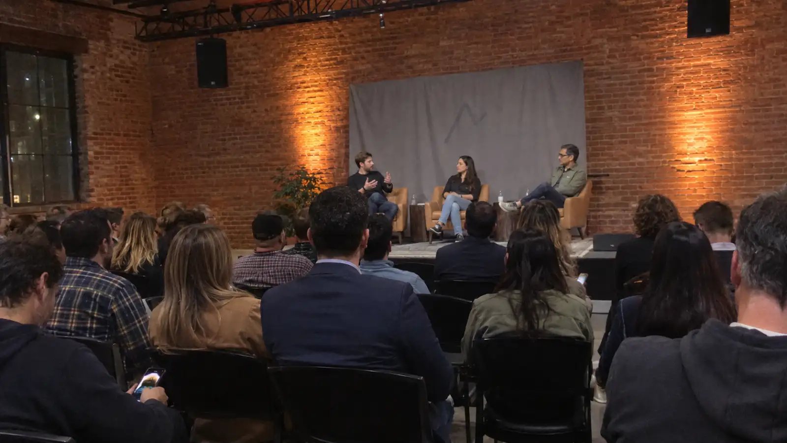Corporate panel discussion with stage lighting in a brick warehouse event venue in Austin