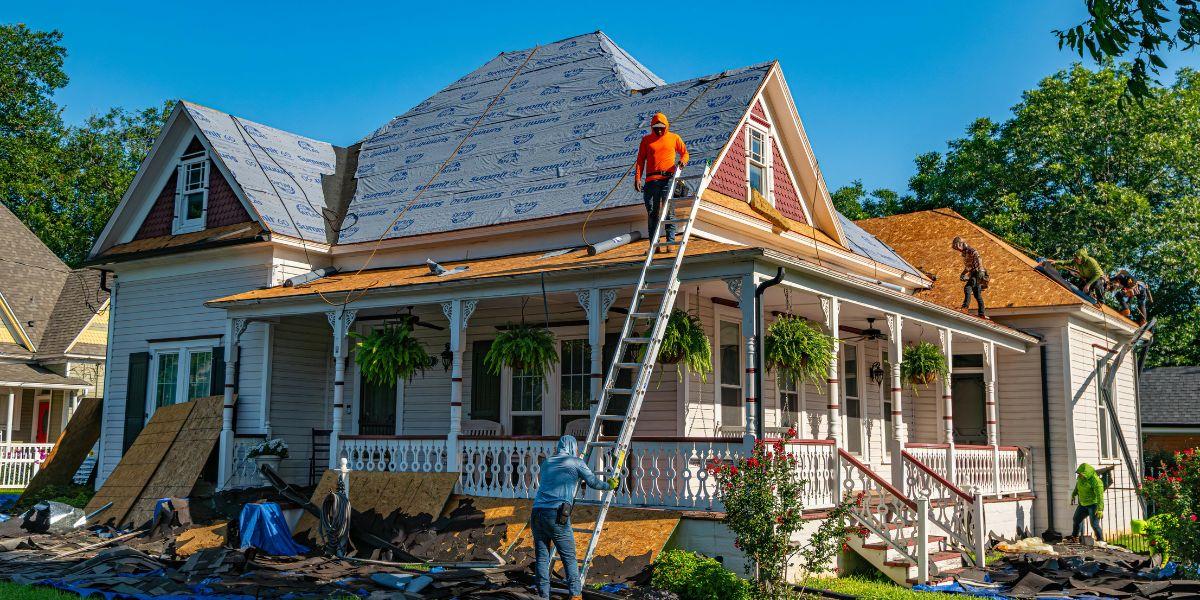 Roofing crew replacing a residential roof while preparing the gutter system and drip edge on a Northeast Ohio home.