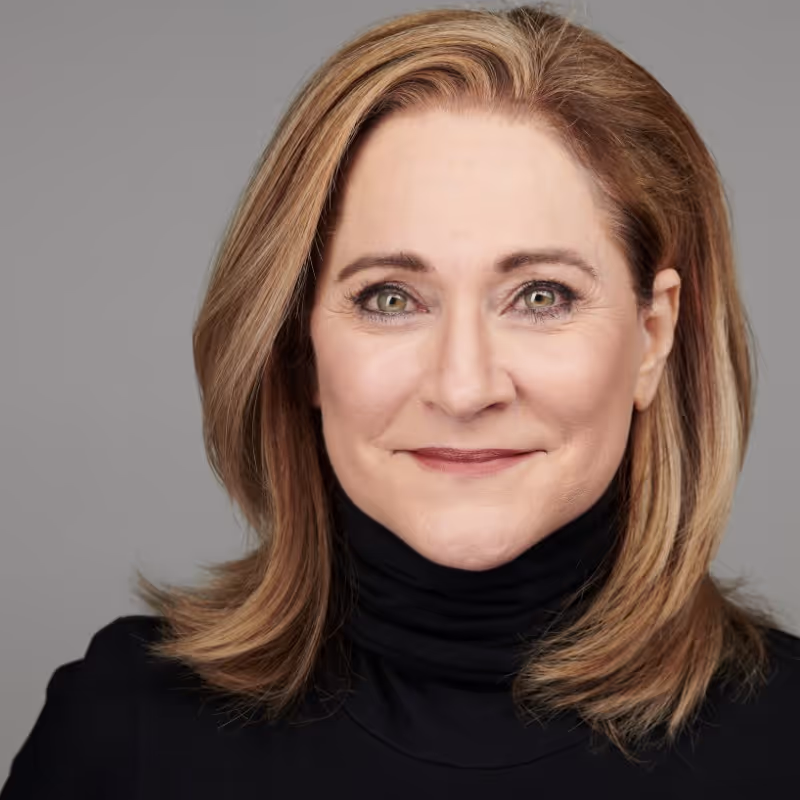 A woman with blonde hair and a black shirt.