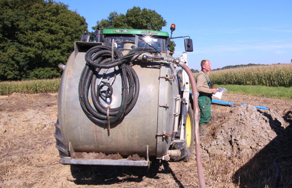 A man standing next to a large machine in a field.