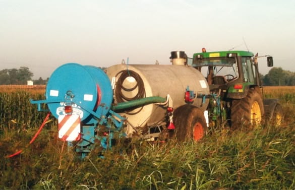 A green tractor with a blue tank on the back.