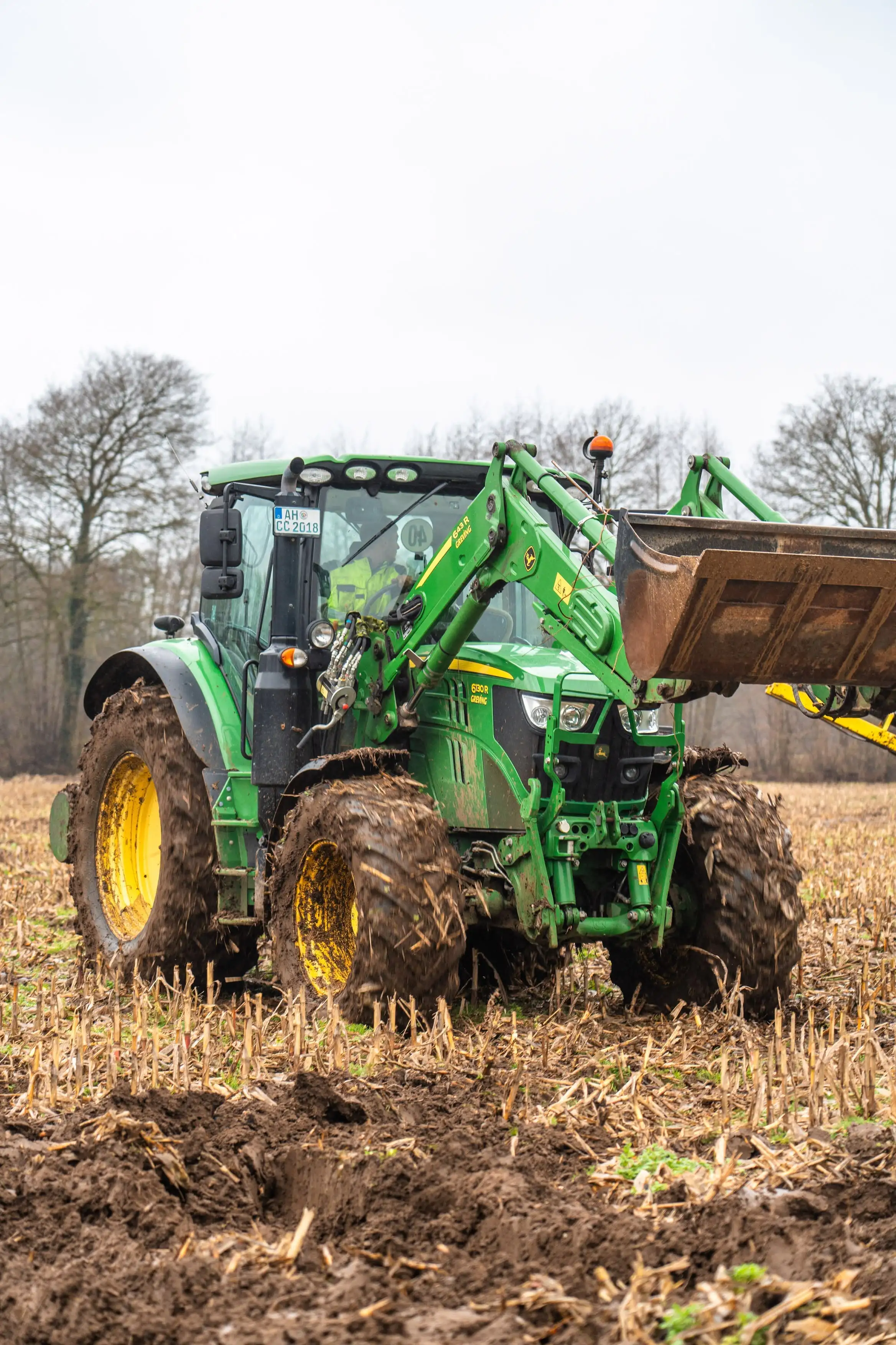 A green tractor with a yellow front tire.