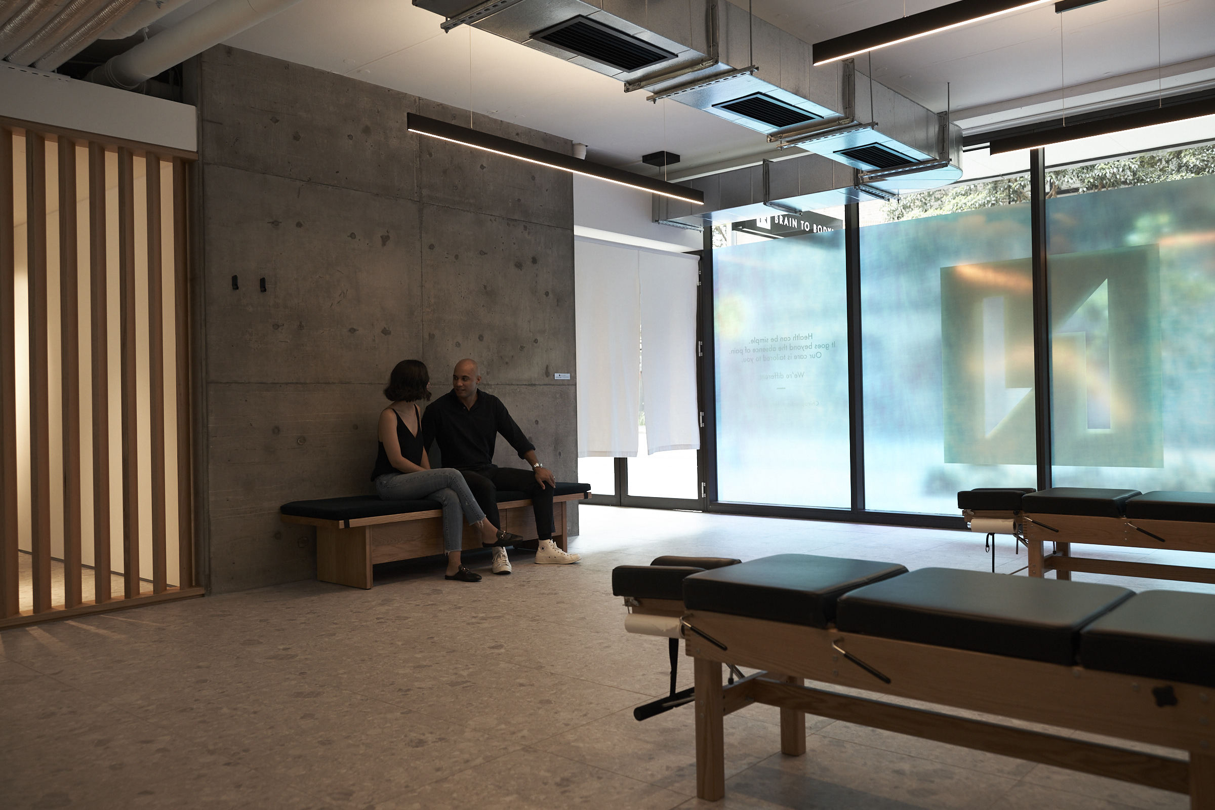 Inside the BRAIN TO BODY® studio in Chippendale with concrete walls and timber adjustment tables