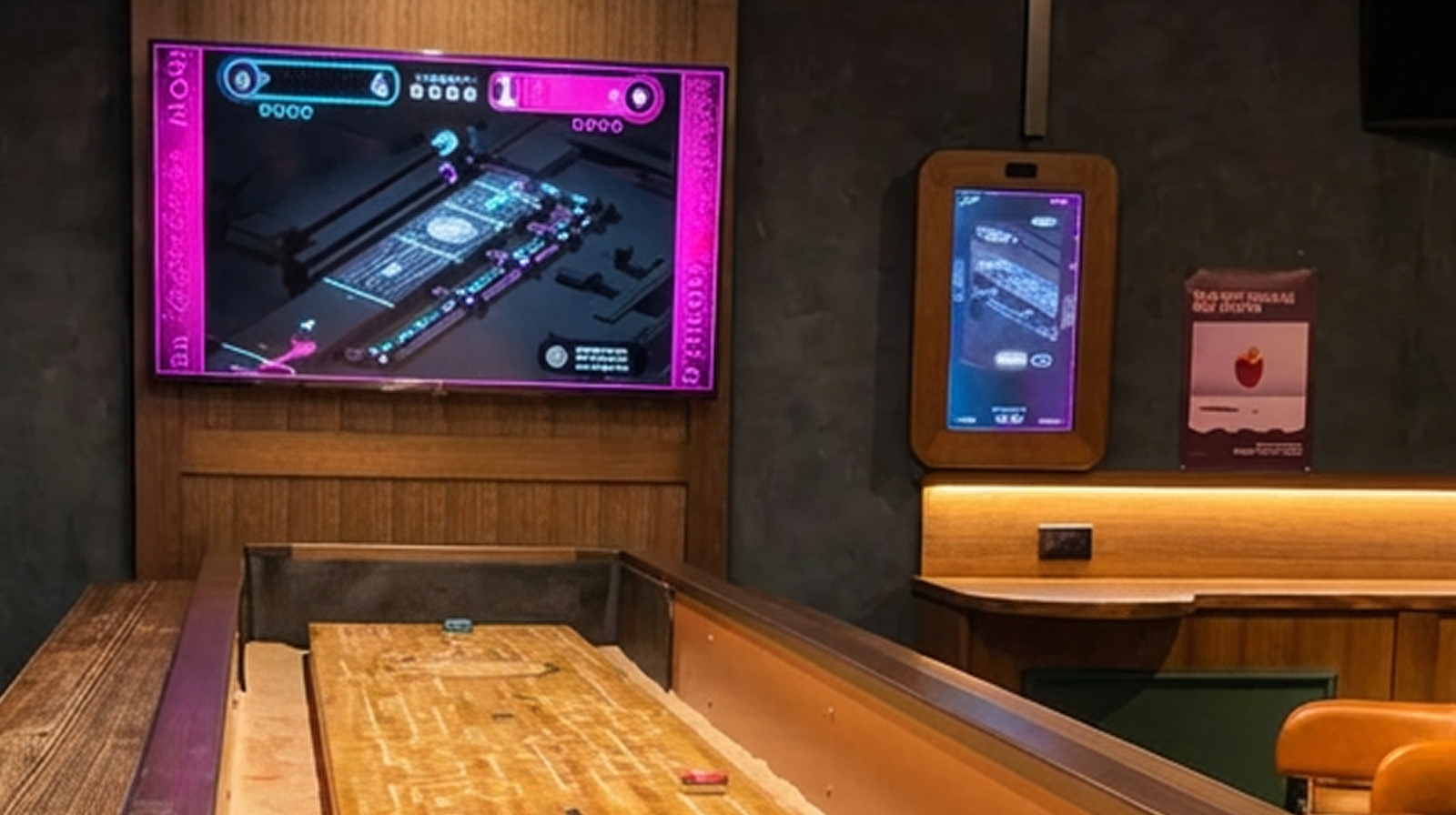 Neoshuffle table in a dimly lit game room with two screens displaying a digital version of the game.