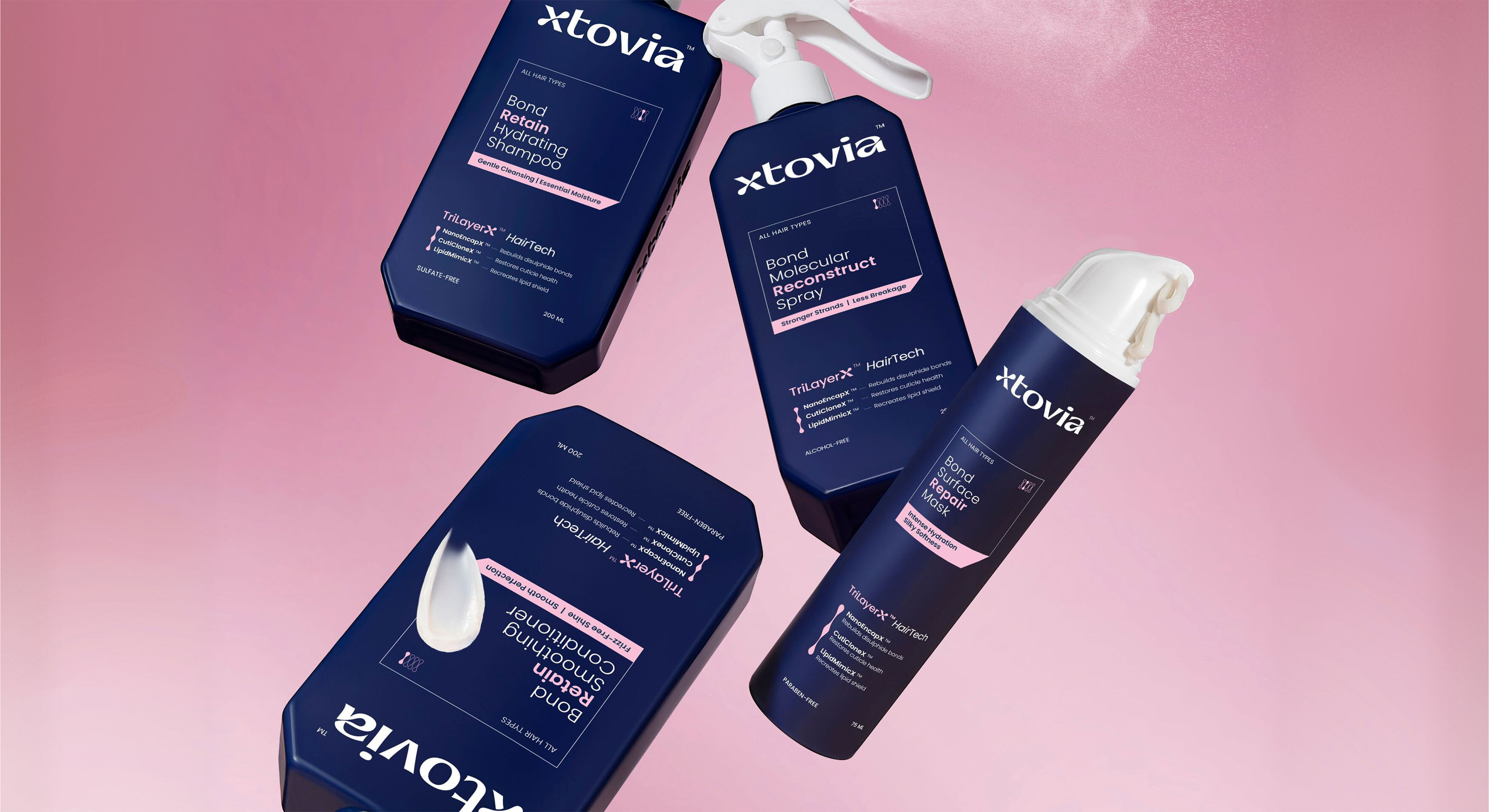Four Xtovia bond repair haircare products including shampoo, conditioner, repair mask and reconstruct spray displayed on a clear acrylic shelf against a soft pink background.