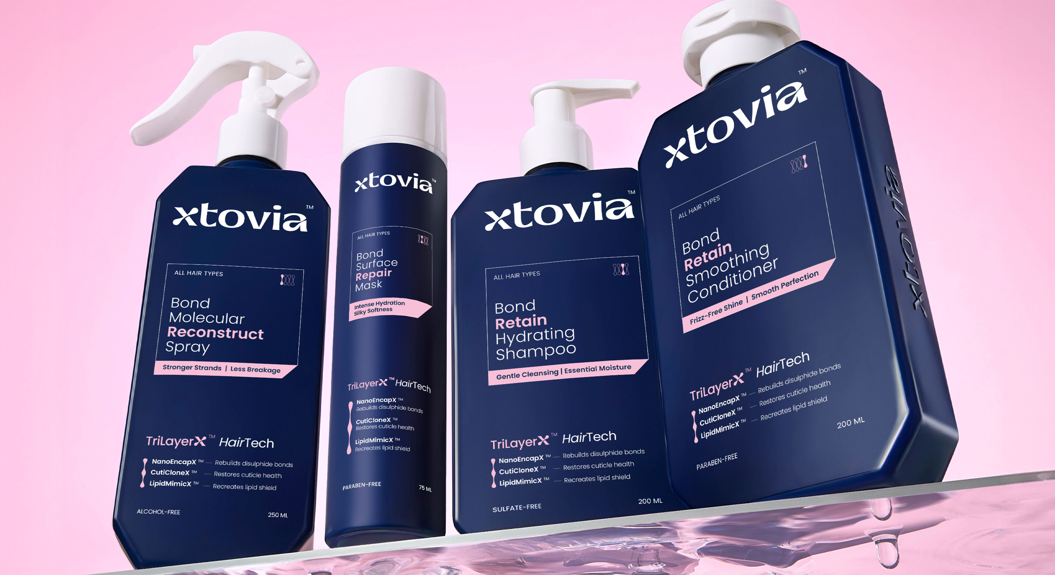 Four Xtovia bond repair haircare products displayed on a clear acrylic shelf against a soft pink background.