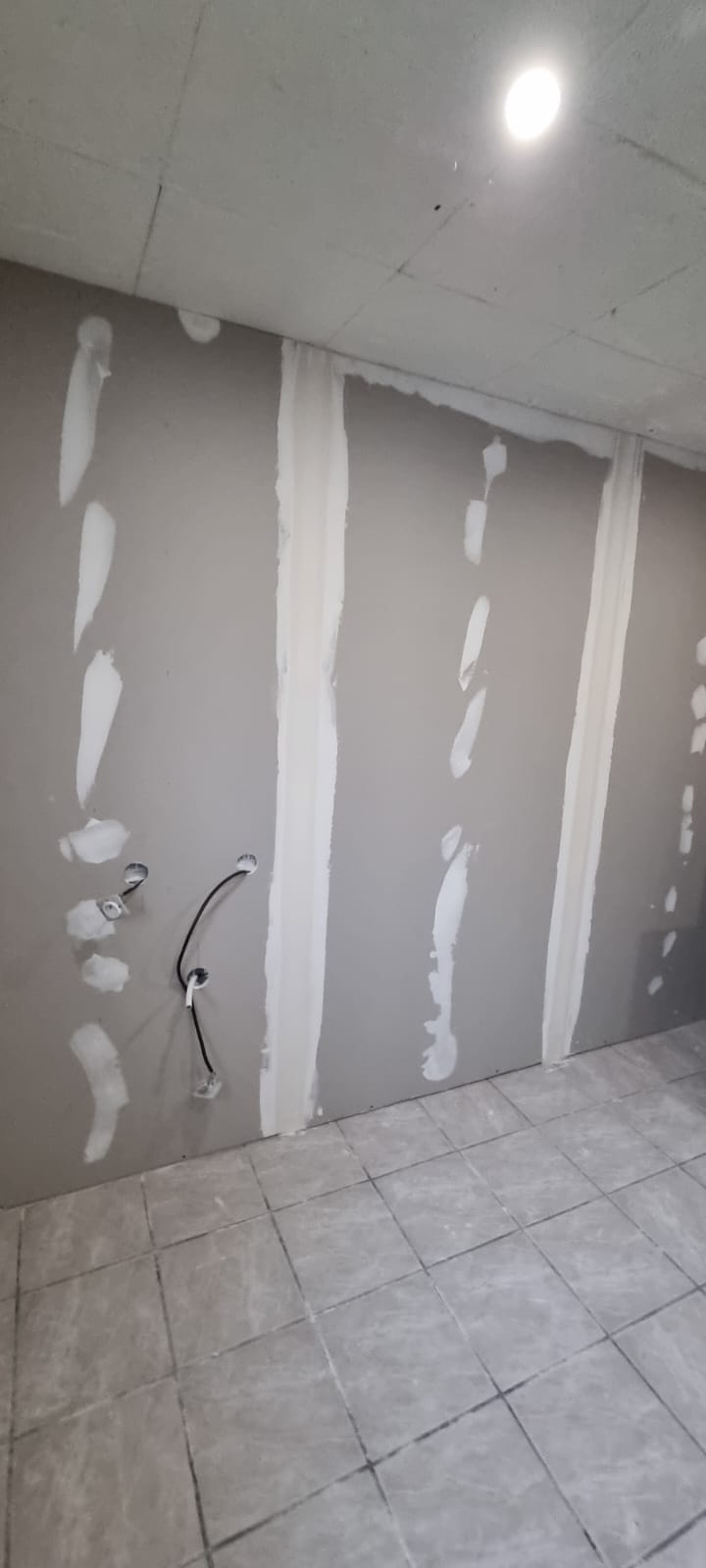 Isolants placo sur un mur intérieur lors d'un chantier d'isolation thermique des combles aménagés