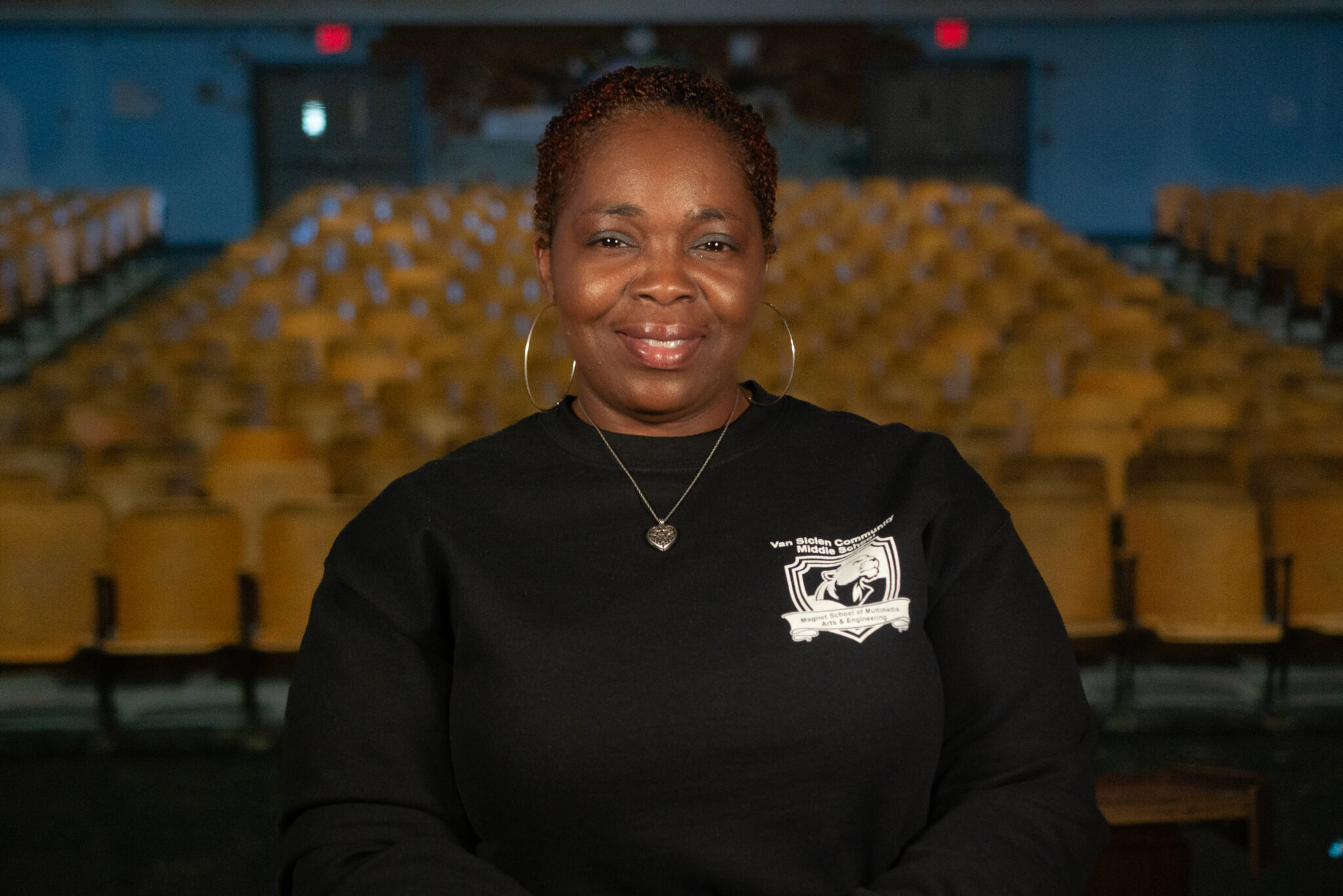 Staff member smiling in Van Siclen Community Middle School auditorium