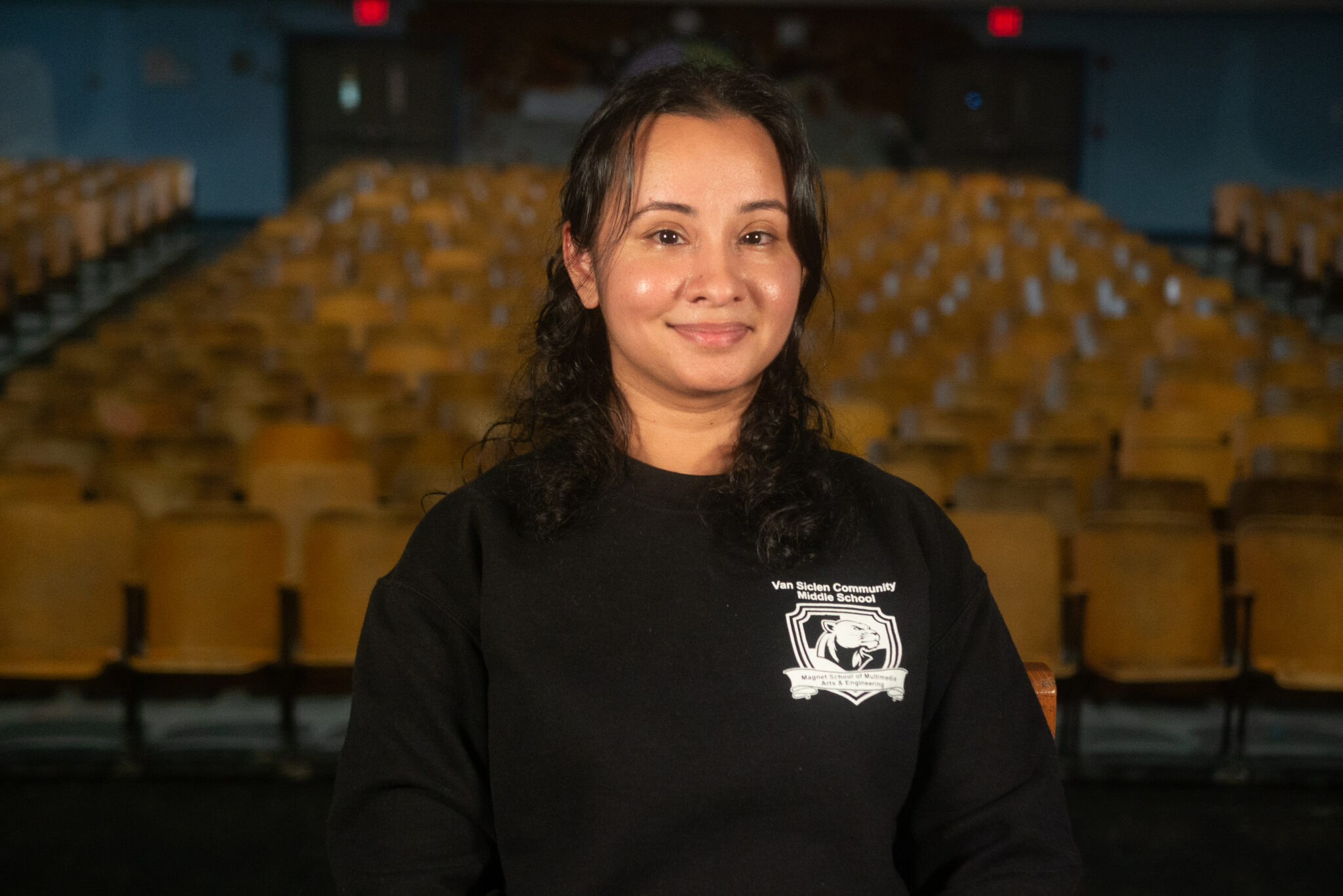 Ramona Persaud smiling in Van Siclen Community Middle School auditorium
