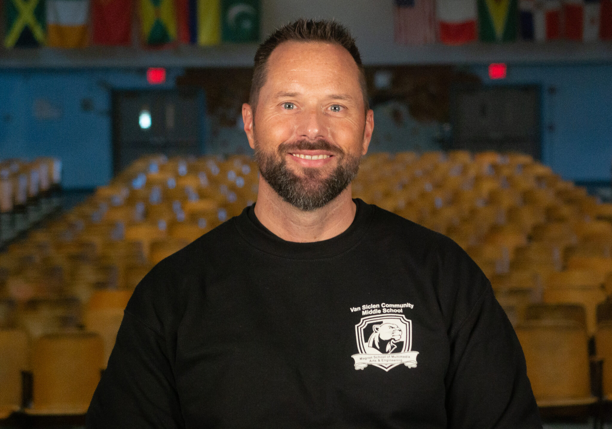 Matthew Dunne staff member smiling in Van Siclen Community Middle School auditorium