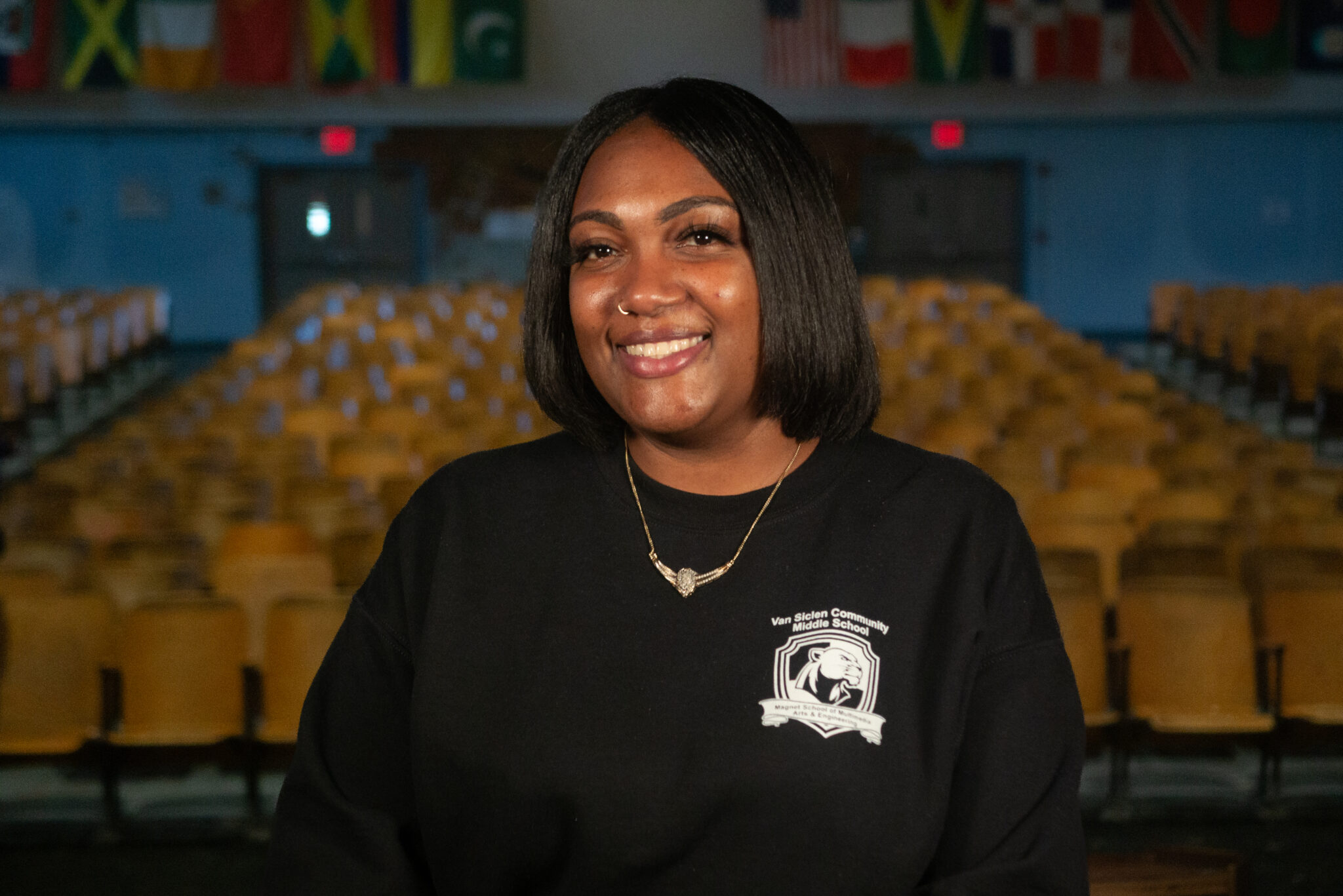 Dominique Legrand smiling in Van Siclen Community Middle School auditorium