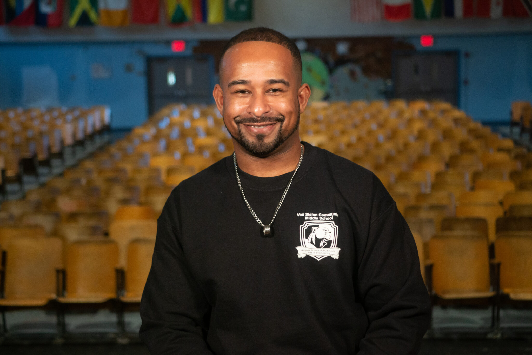 Staff member smiling in Van Siclen Community Middle School auditorium