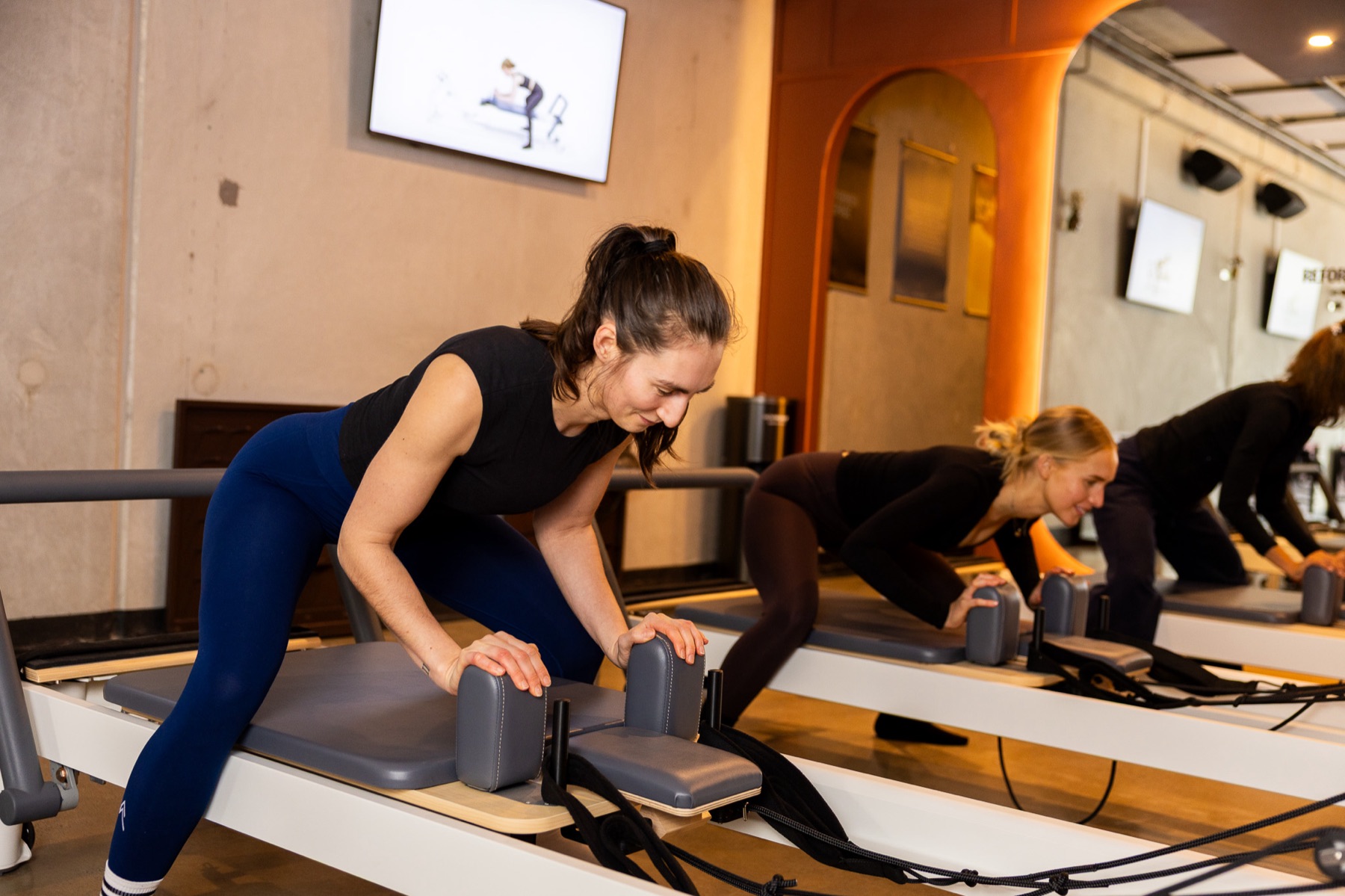 Two members working through an exercise on the reformer