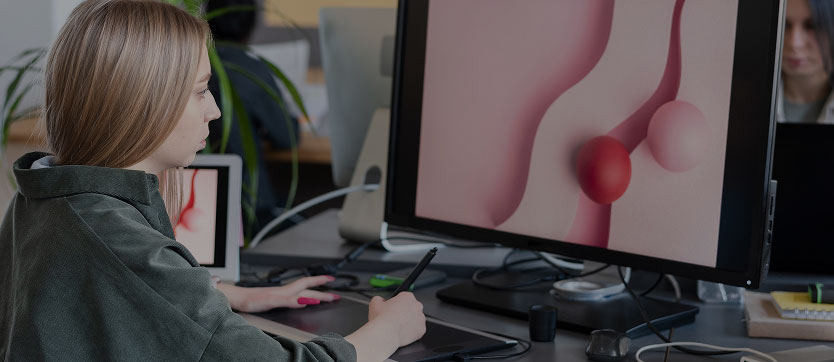 Une jeune femme travaille avec application à son bureau, stylo numérique en main, pour donner vie à une scène de motion design 3D. Sur son écran, la scène prend forme, témoignant de la maîtrise des outils digitaux et de l’imagination au service de la création visuelle et de la narration animée.