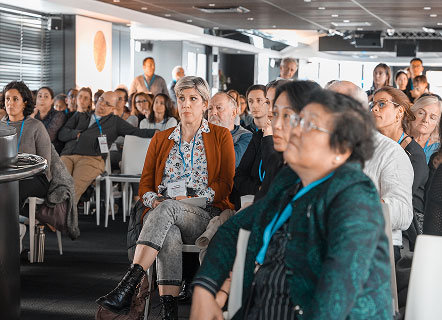 Salle de colloque remplie de participants, tous les regards fixés sur l’intervenant. L’image souligne l’intérêt du public, l’attention portée aux experts et l’atmosphère studieuse qui caractérise les événements de partage de connaissances et de débats professionnels.