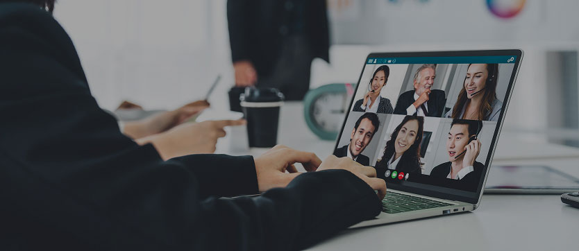 Vue d’une personne à table devant son ordinateur : l’écran affiche la liste ou la galerie des participants d’un webinaire. L’image met en avant la dimension collaborative et interactive des événements virtuels, permettant de voir et d’interagir avec les autres participants, tout en bénéficiant des fonctionnalités avancées des plateformes de webinaires.