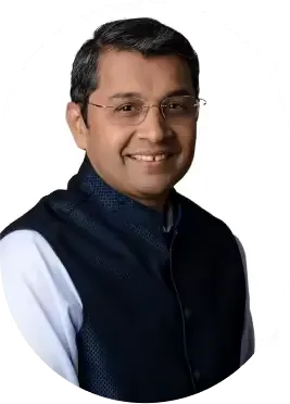 Smiling man wearing glasses and a dark vest over a white shirt, facing forward.