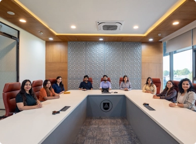 Eight people seated around a U-shaped conference table in a modern meeting room at DevX Gift City.