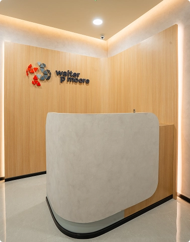 Walter P Moore modern office reception desk with Walter P Moore logo on wood-paneled wall behind it.