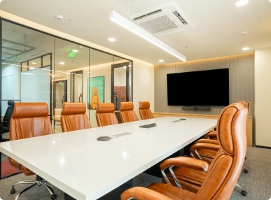 Walter P Moore modern conference room with white table, brown leather chairs, glass walls, and a large wall-mounted TV.