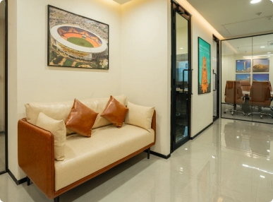 Walter P Moore modern office hallway with beige sofa, brown cushions, framed artwork, and glass conference room.