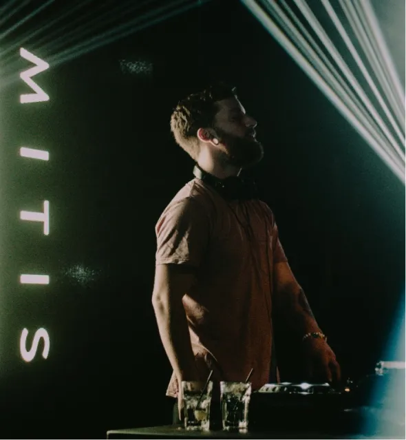 a closeup of a dj on a dance floor with green colors