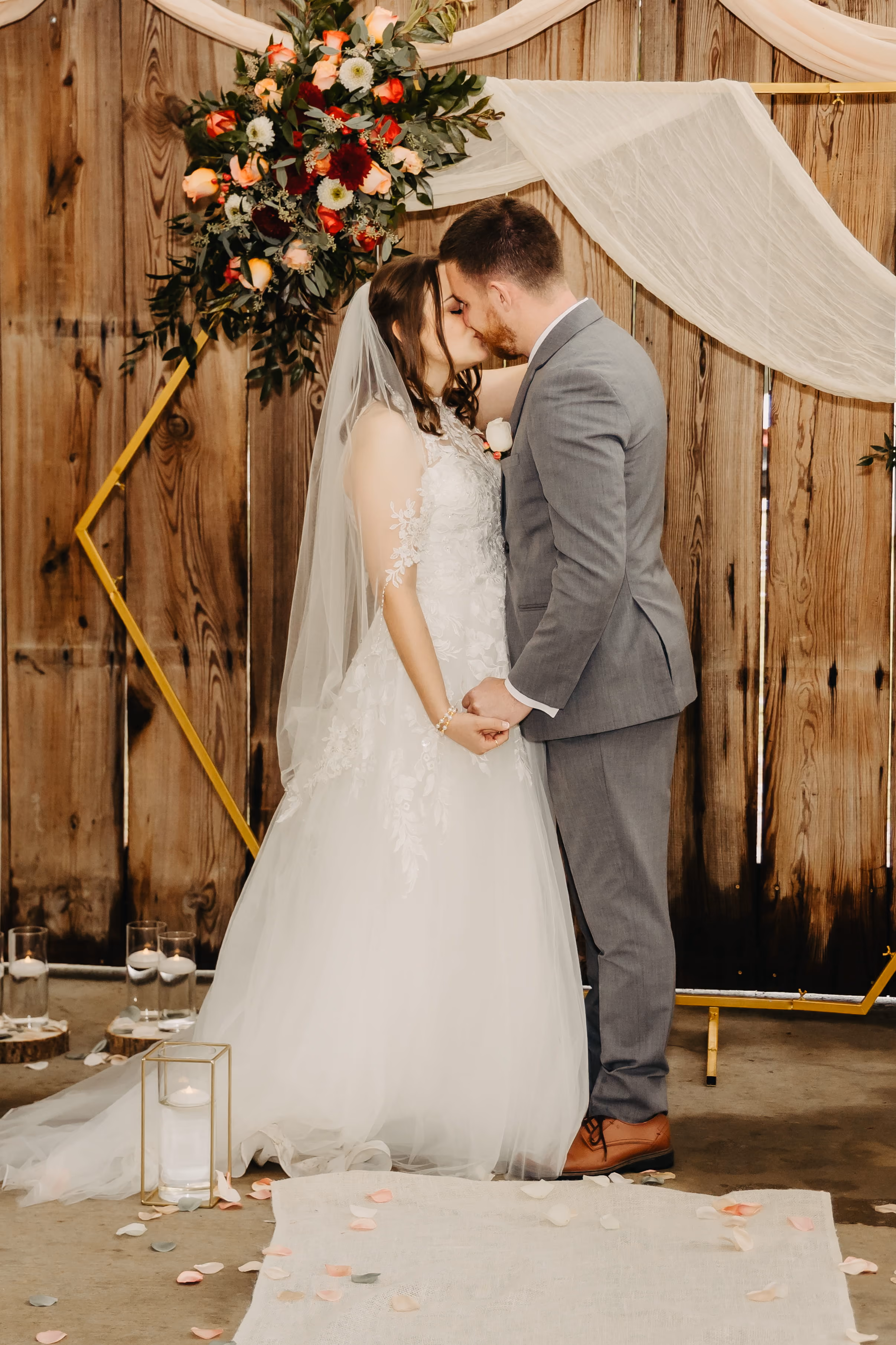 A couple at a wedding ceremony sealing their marriage with a first kiss. 