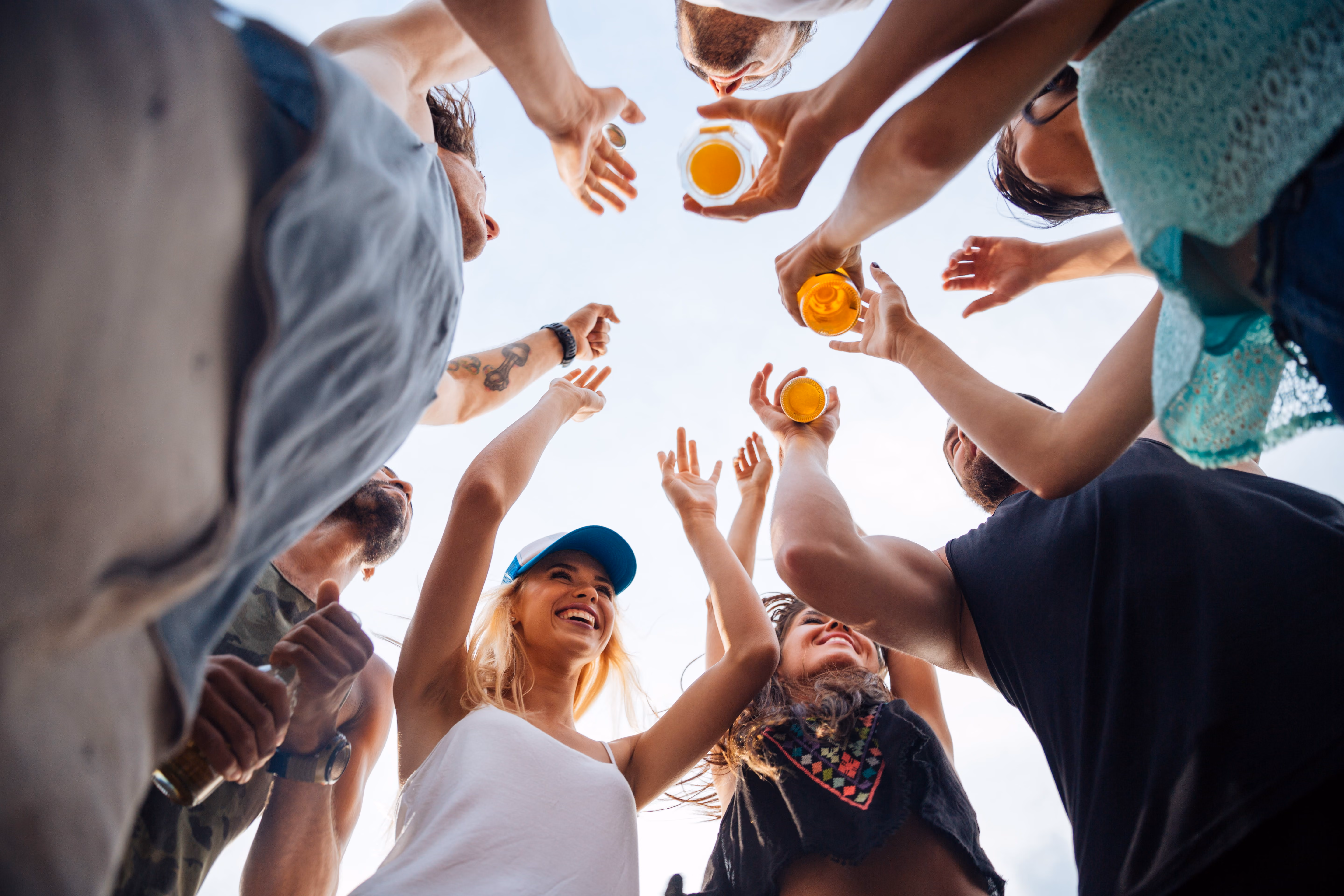 A group of friends standing in a circle raising a glass.