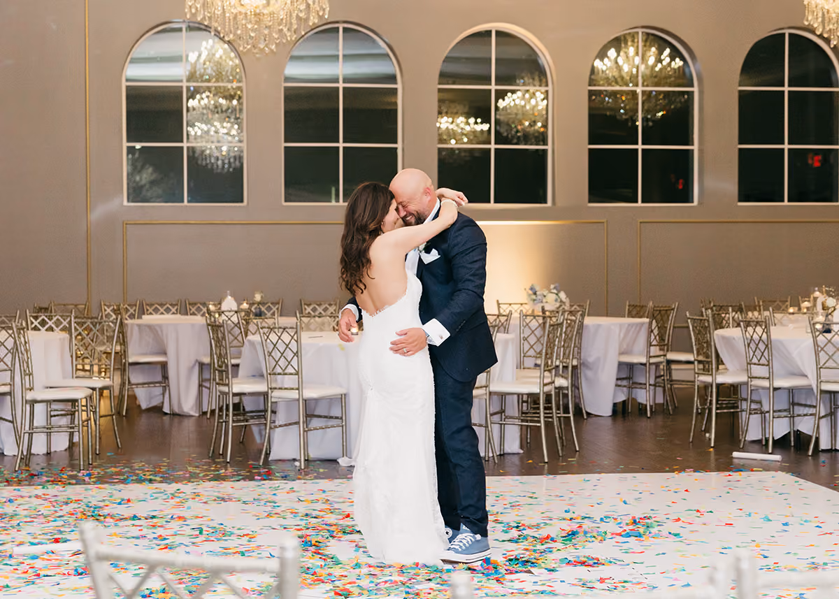 A bride and groom sharing a last dance at the end of their wedding reception. 
