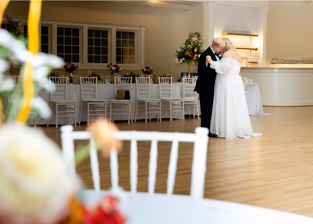 A bride and groom dancing to one last song at their wedding reception. 