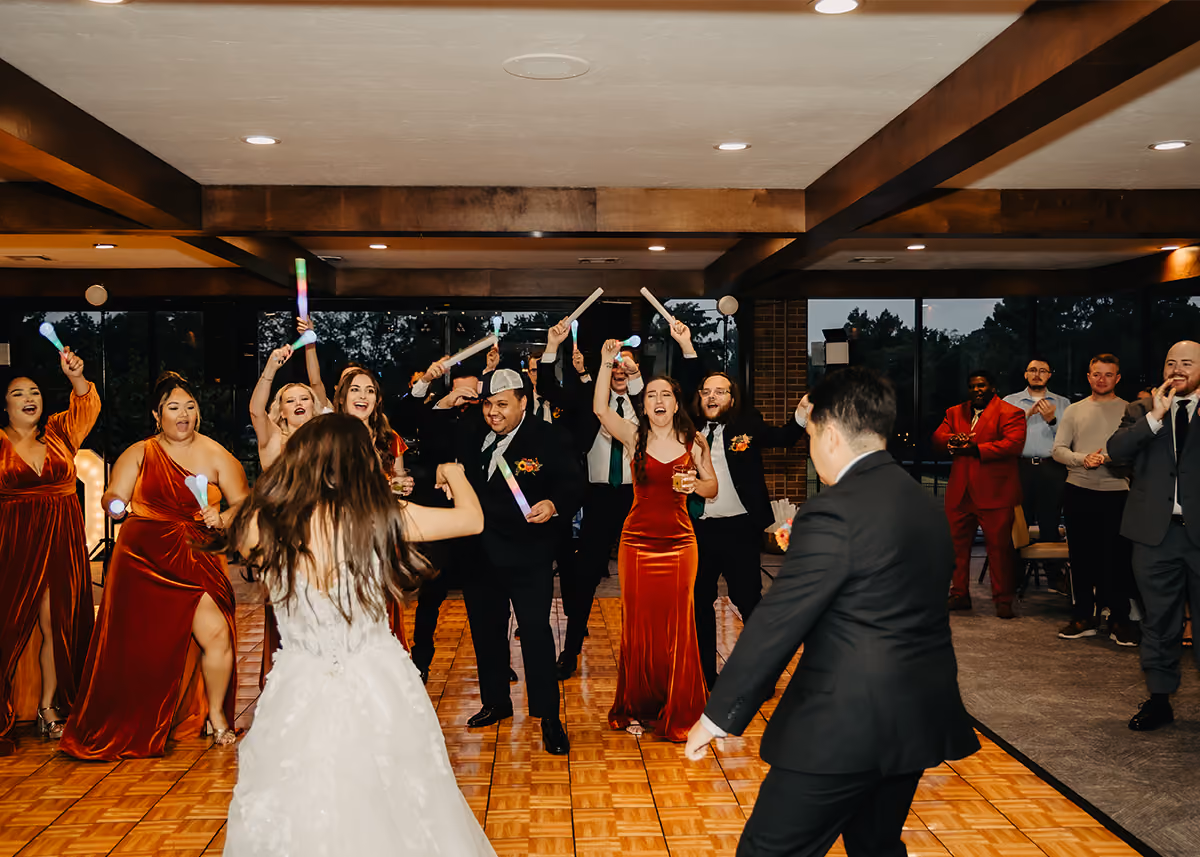 A wedding dance floor filled with guests dancing with LED glow tubes. 