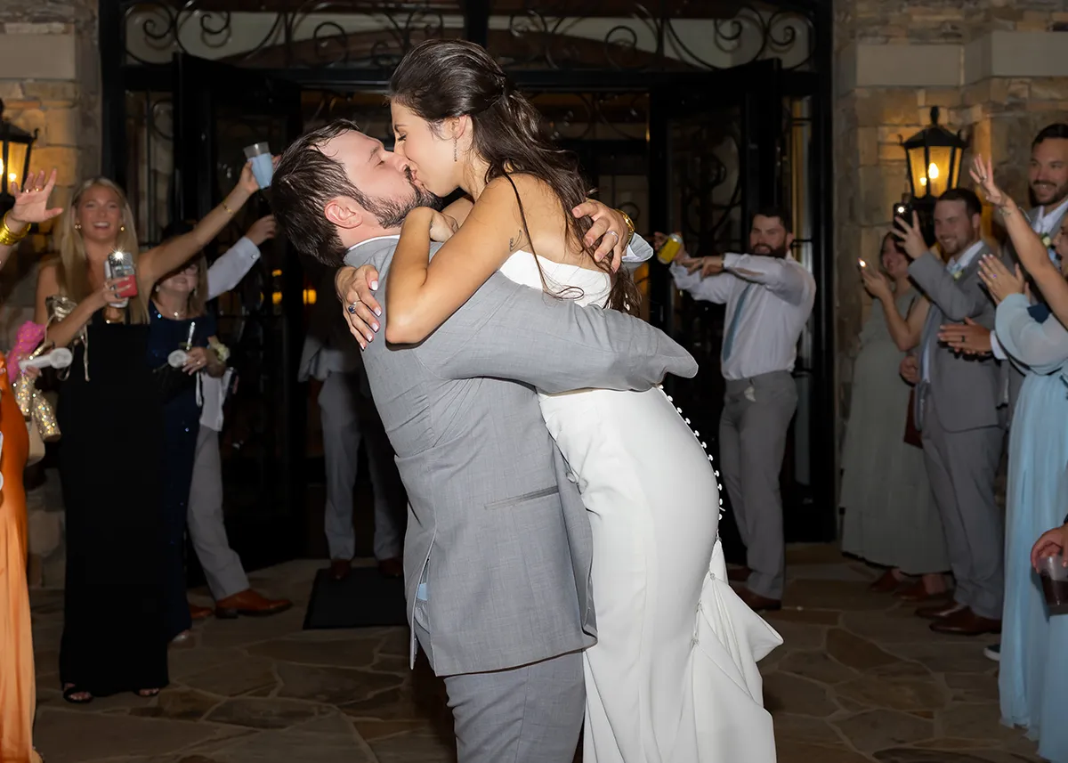 A just married couple kissing while the husband raises up his wife.