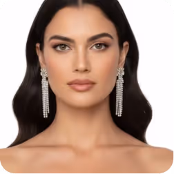 Portrait of a woman with long dark hair wearing dangling crystal earrings and neutral makeup.