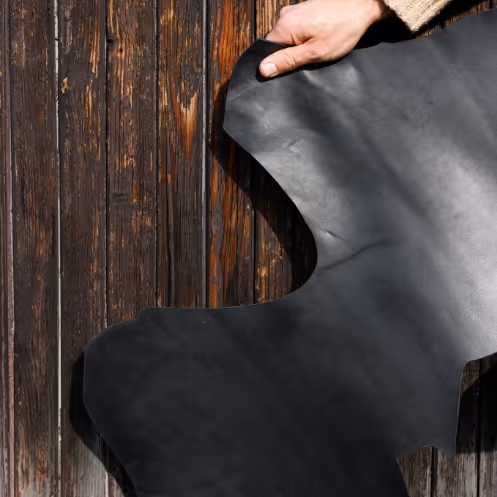 A person holding a black piece of leather.