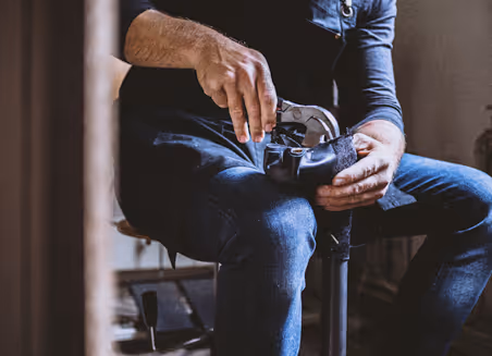 A man sitting on top of a stool holding a cell phone.