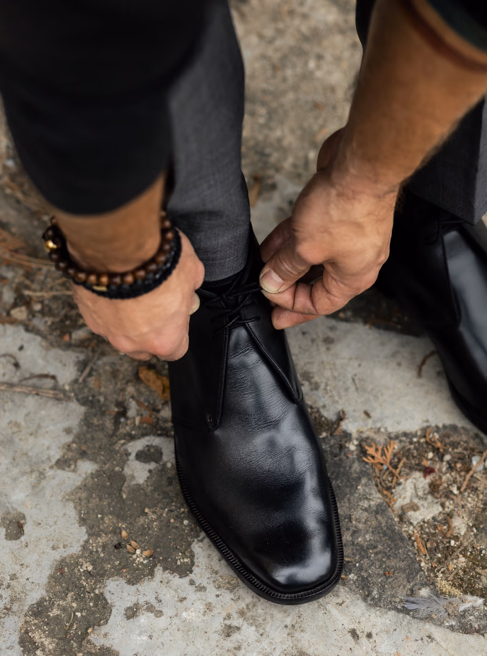 A man tying a pair of black shoes.